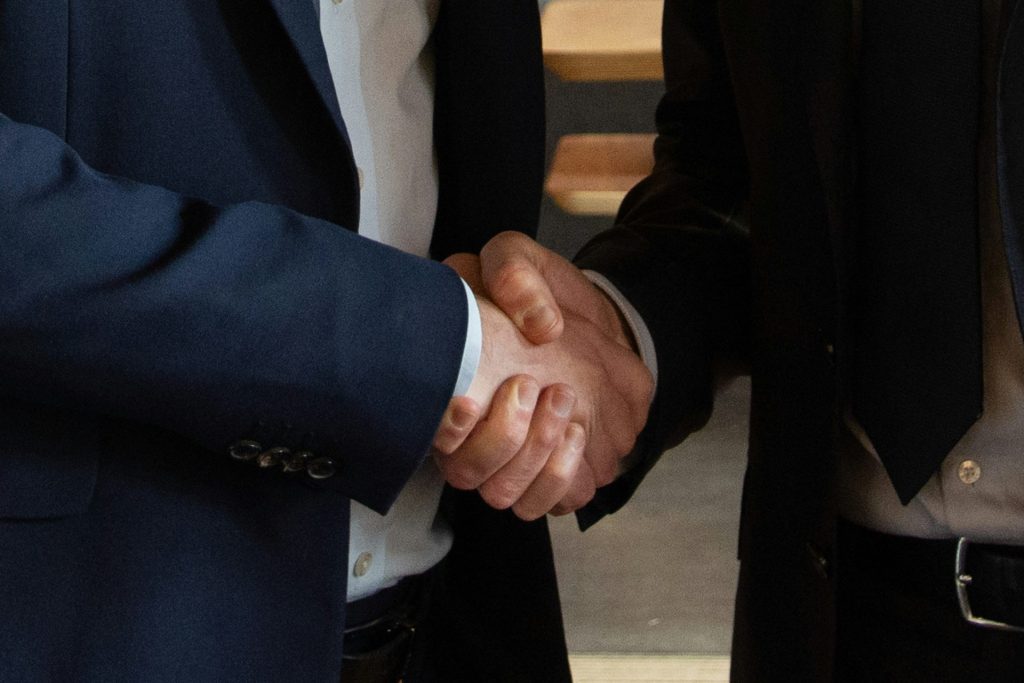 Business partners shake hands, making a deal.