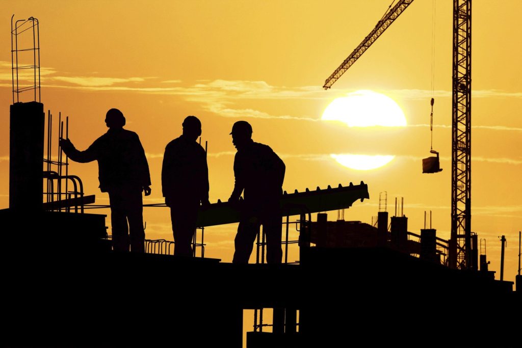 Construction workers at sunset